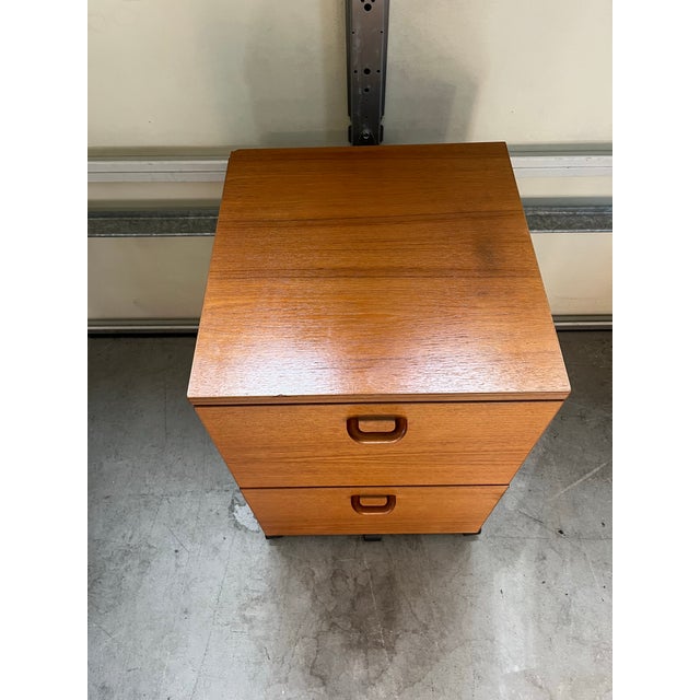 This is a vintage Danish Modern teak filing cabinet on casters, typically dating from the 1960s or 1970s.These mobile...