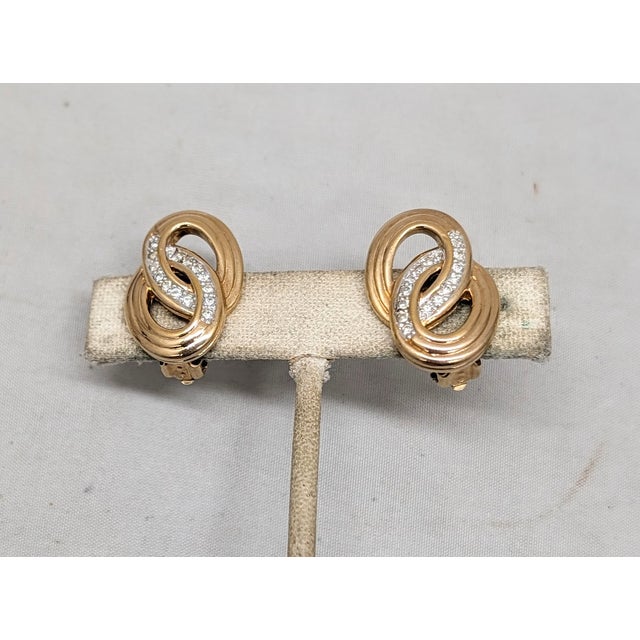 1980s goldtone textured figure-8s with round clear rhinestone accents clip earrings. Marked "PANETTA" on the clips and...