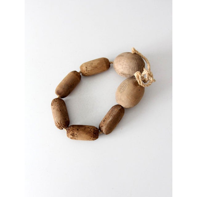 This strand of vintage wooden fishing net floats carries a beautifully weathered coastal character with hand-turned wooden...