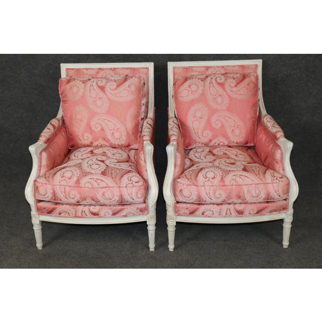 A beautifully tailored and exceptionally inviting pair of French Louis XVI-style bergère armchairs dating to the 1950s,...