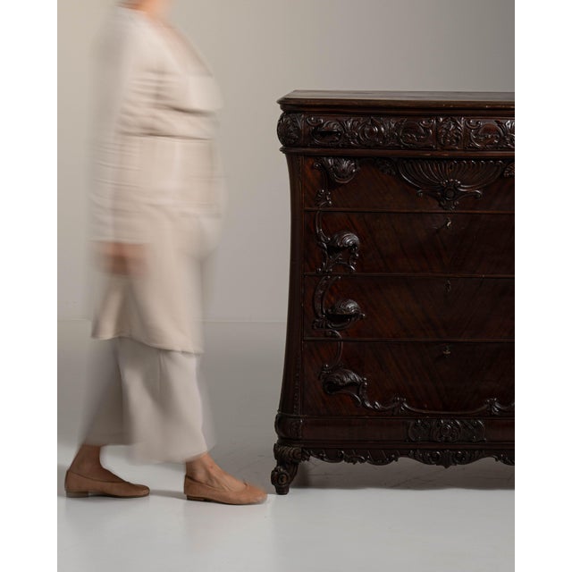 This 19th century Louis XV ornate chest of drawers from France is made in dark, carved wood with five drawers and a...