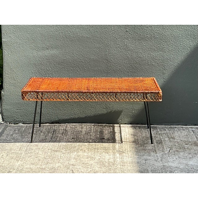 This vintage woven rattan and metal coffee table pairs a warm, amber-toned rattan top with sleek tapered metal legs for an...