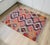 This authentic 1950s Mediterranean Anatolian kilim features a vibrant geometric design in deep plum, orange, and cream,...