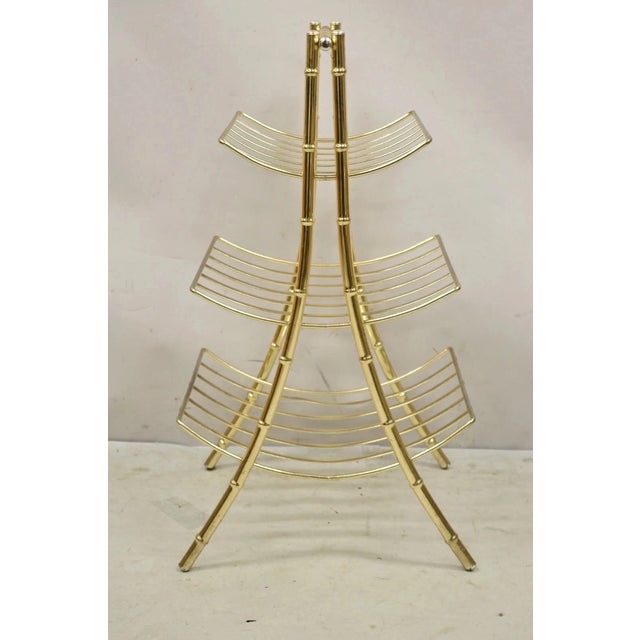 Vintage Hollywood Regency Gold Metal Faux Bamboo 3 Tier Magazine Rack Stand. Circa Late 20th Century. Measurements: 27" H...