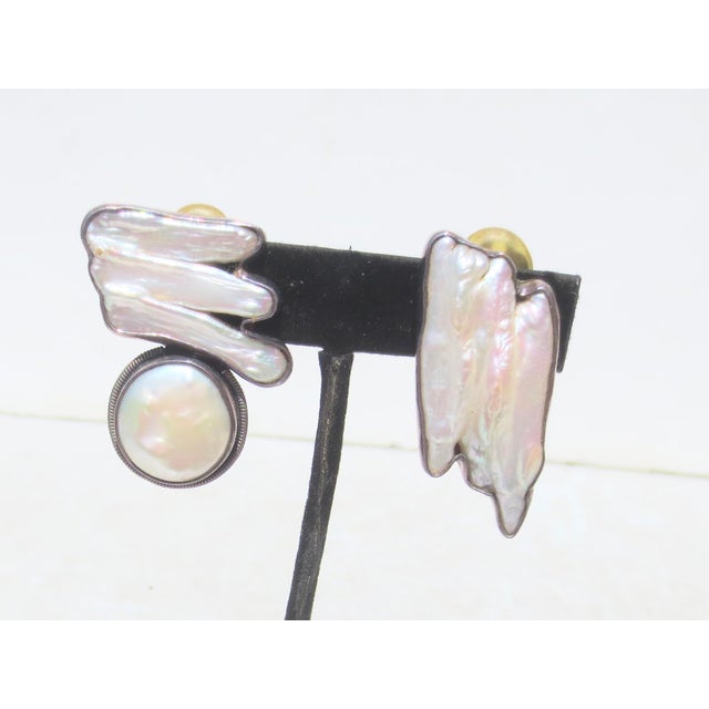 A creation of baroque pearls set in an abstract design, clip-on in sterling mounts with irregular form. Lovely opalescent...