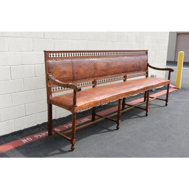 Impressive Early 20th-century Spanish Colonial style long bench featuring richly carved solid wood construction and...