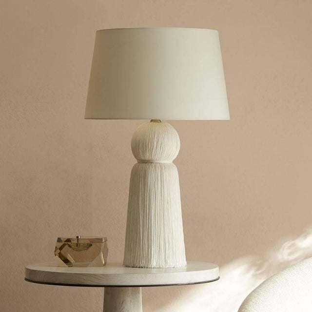 Fringe is a fashion favorite, and Laura Kirar has taken it into the home. This ivory "tassel" lamp has an ivory microfiber...
