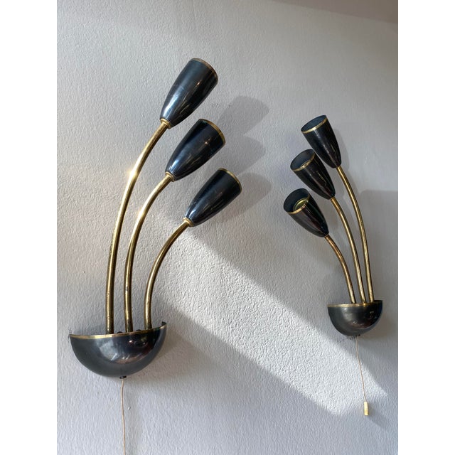 Pair of wall lights, Italy circa 1955, attr. Prod. Stilnovo, dark silver / gray shiny metal with brass rim, three brass...