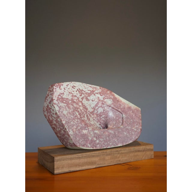 A stylish and beautifully carved pink stone sculpture (soapstone or alabaster?) on a wooden base (it is not attached to...