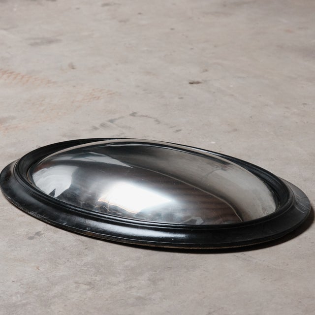 This mid-century convex “witch” mirror features a gently bulging glass lens housed in a streamlined circular frame, its...