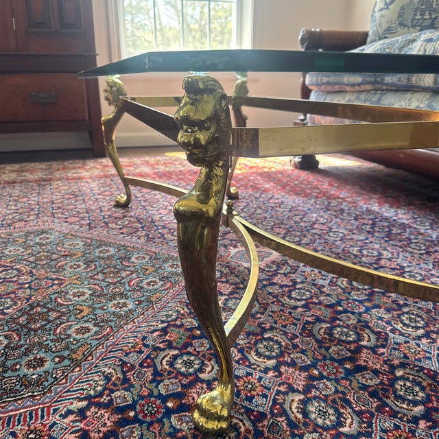 2 Elegant coffee tables with thick glass top with beveled edges. Frame is solid brass with ornate ram head details on...