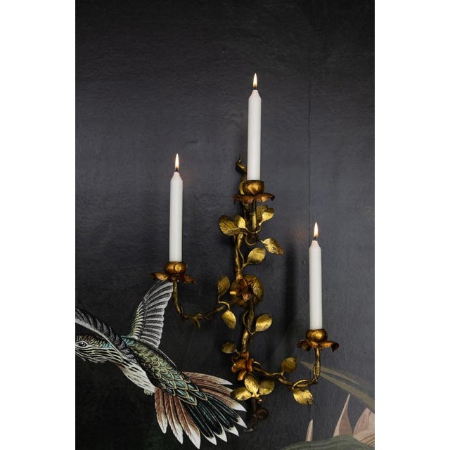 Hollywood Regency gilt tole wall sconce, circa 1970s. Romantic three-arm wall candle sconce crafted in gilt tole metal,...