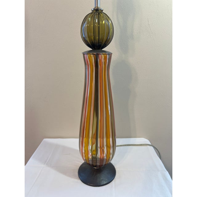 Aurora finish, base is striped in ribbon glass-Aurora (gold, orange and olive). Single glass globe in olive just under the...