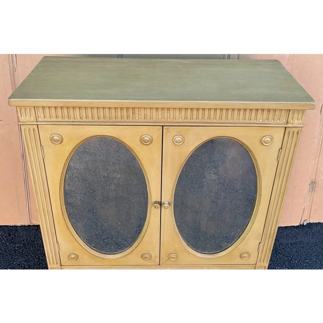 This is a pair of mid-century regency style side cabinets with mirrored inset panels. They open to a single interior...