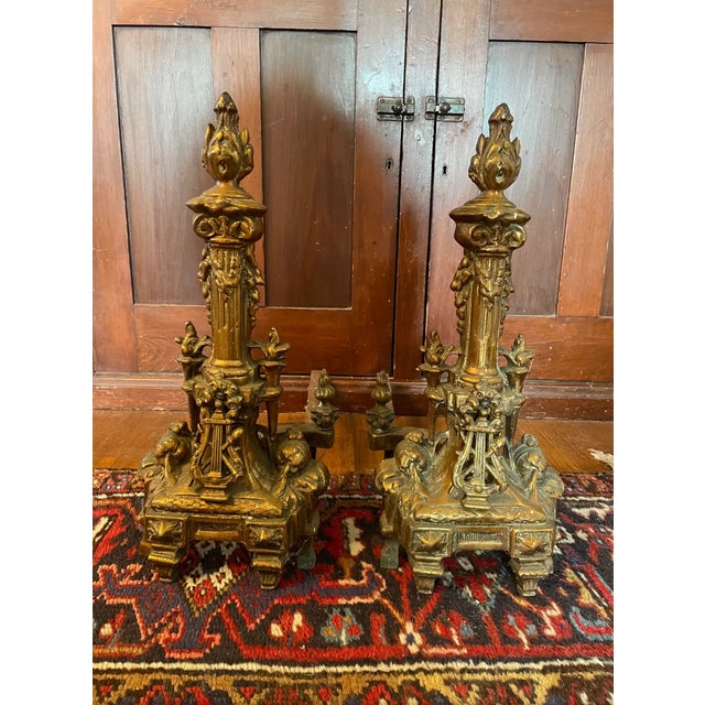 Very special pair of classical French bronze adirons. Ornate detail including a lyre, garland, fruit.