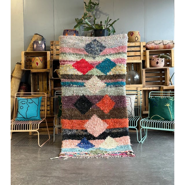 Immerse yourself in the rich tapestry of Moroccan culture with this exquisite Vintage Moroccan Berber Boucherouite Rug....