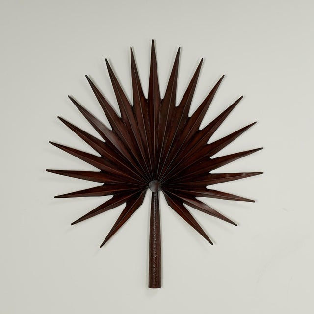 Chic mid century stylized sculptural palm frond wall ornaments crafted in metal with a bronze like finish.