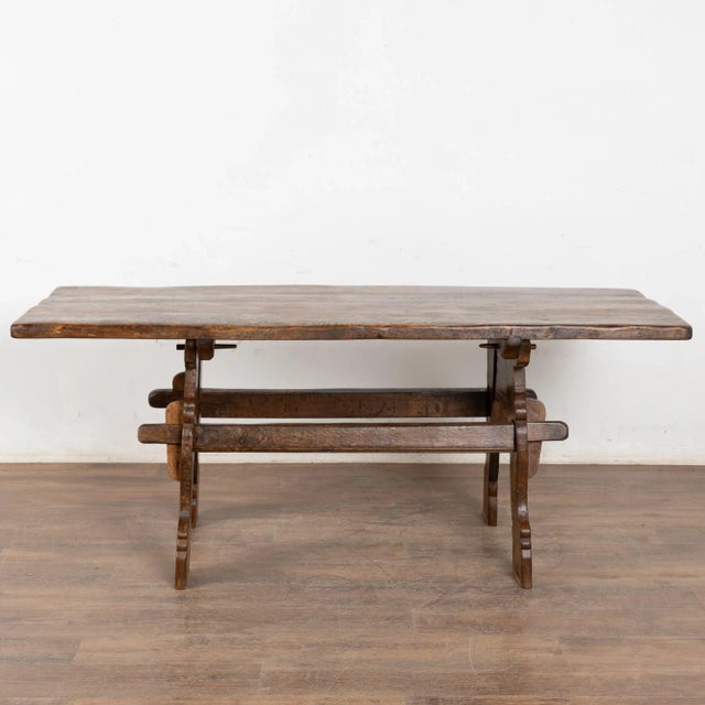 It is the deep aged patina seen in the top and trestle base that draw one to this 6' long farm table from France. Constant...