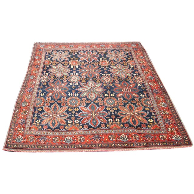 The navy indigo field displays a three by four allover pattern of palmette octofoils in teal, red and rose, with smaller,...