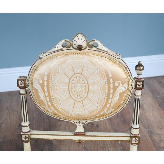 Refined pair of French painted Neo Classical chairs Circa 1910 The chairs are upholstered in a luxurious golden satin...