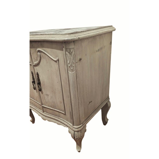 This is a French provincial-style nightstand with a distress finish and cabriolet legs. We don’t know where it was made;...
