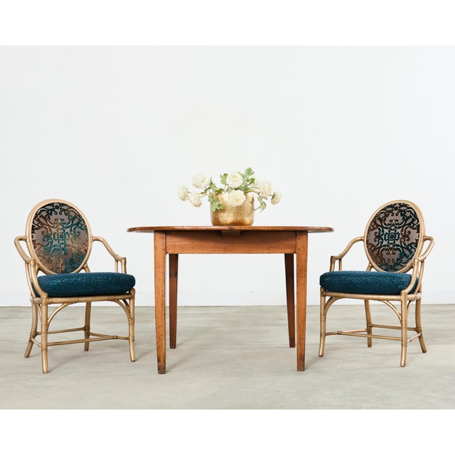 Dramatic and opulent set of eight McGuire rattan and cane dining chairs featuring a gilt lacquer finish. The chairs have a...