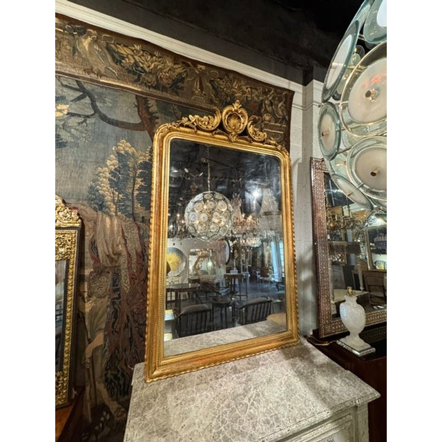 The product is a 19th century French Louis Philippe mirror featuring a crest and Greek key pattern. This stylish mirror...