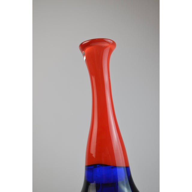 Elegant hand-blown art glass soliflore featuring a striking two-tone composition with a deep cobalt blue body and an...