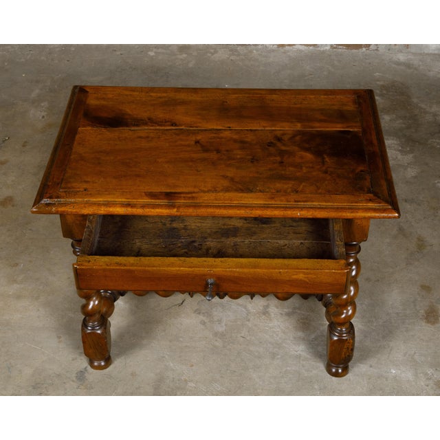 An English Georgian period walnut barley twist side table from the early 19th century with single drawer and H-Form cross...