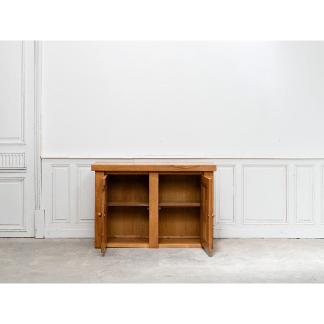 Solid elm sideboard dating from the 1970s. We love its raw, graphic lines, highlighted by the attractive geometric design...