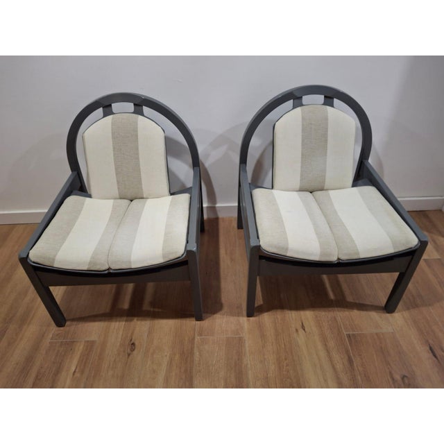 Original French Baumann armchairs dating from the 1980s. This model features a distinctive semi-circular backrest and is...