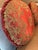 A pair of matching round, silk pillows in a beautiful rose/crimson red. The pillows are trimmed with a brush fringe in a...
