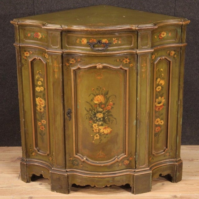 Large Venetian corner cabinet from the first half of the 20th century. Finely carved, lacquered, and hand-painted wooden...