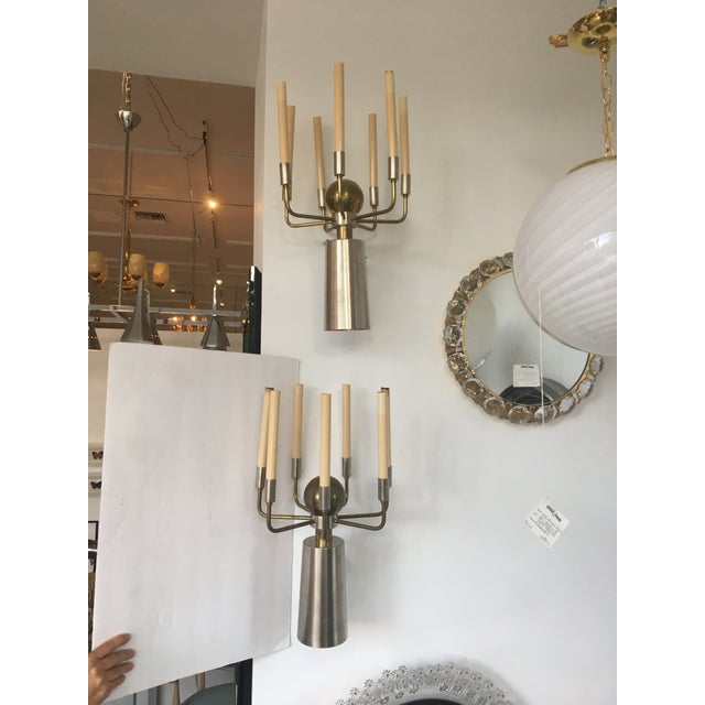 Pair of French two tone steel and brass sconces. The sconces project off the wall in a dramatic profile with tall...