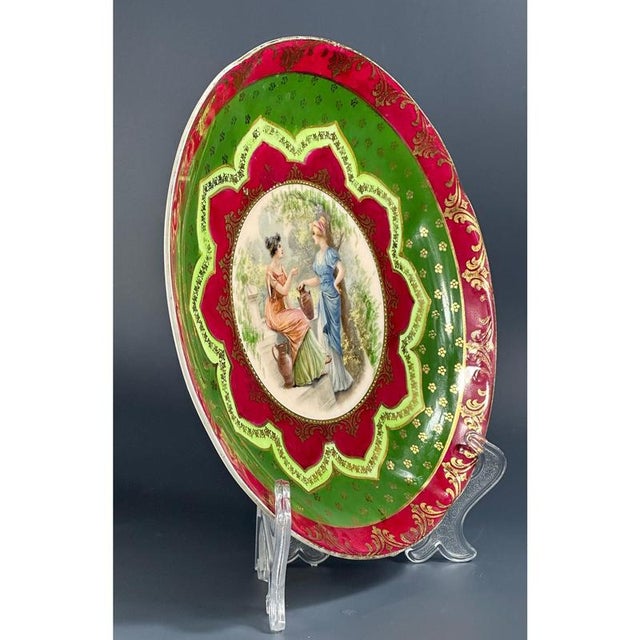 The plate is richly decorated with gold ornaments and classic colors for Austrian porcelain (green and burgundy). In the...