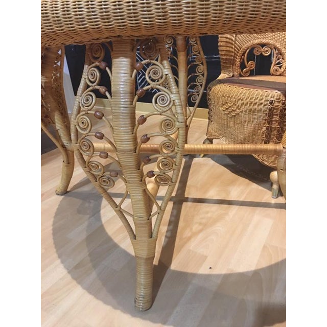 Custom made, rattan barrel back dining set. Featuring peacock scrolls and beading details on both table and chairs. The...