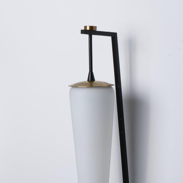 Italian wall sconce dating from the 1950s, characterized by a slender geometric structure and a refined combination of...