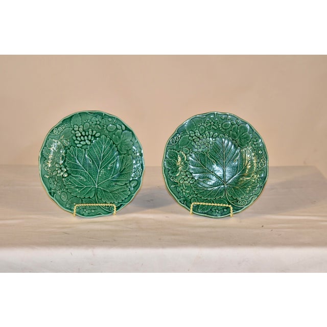 Pair of 19th century green majolica leaf plates from England. This is a lovely pair of berry, vine and leaf plates with a...