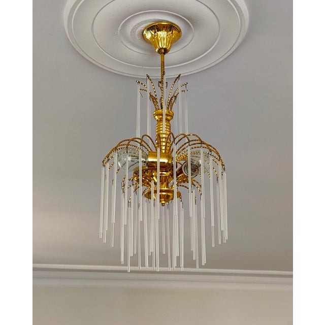 Antique brass chandelier with milk white glass rods, fully rewired and restored, offering elegant vintage lighting for...
