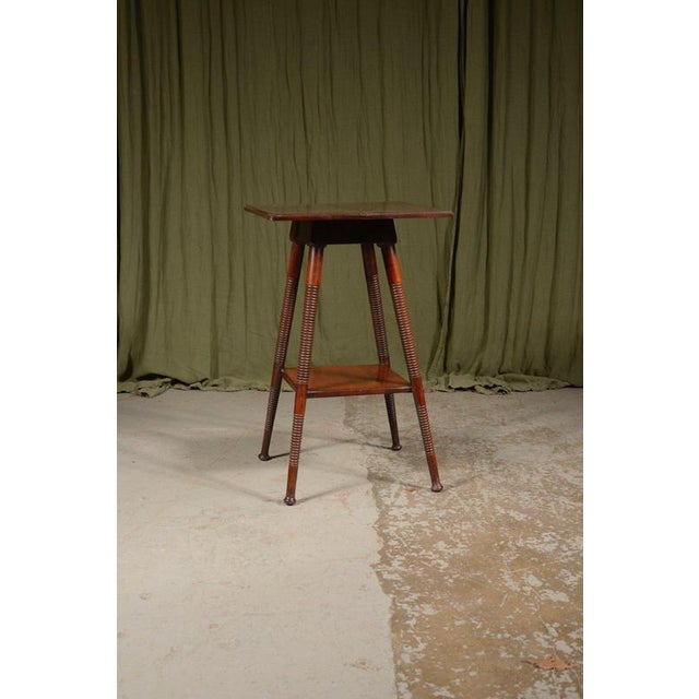 A stylish and useful late 19th century lamp table design by William birch, in black walnut, on ring turned splay legs with...