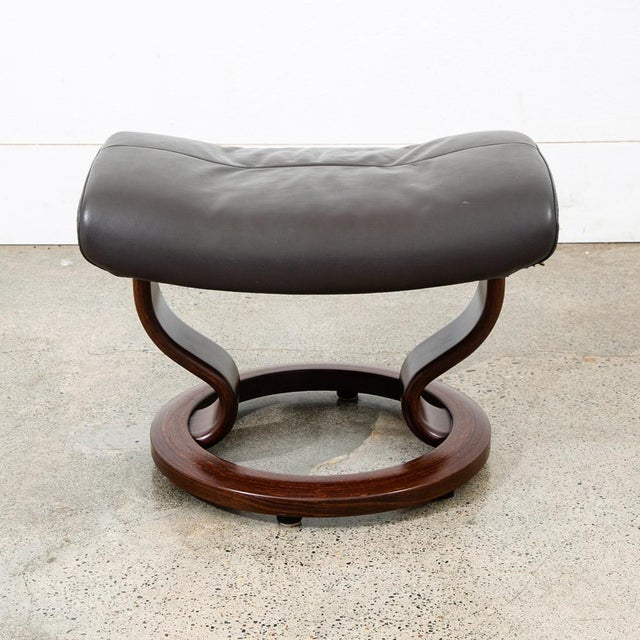 Attributed to Ekornes brown leather / cognac leather swivel ottoman. Piece is stamped beneath. Swivels as intended. Unmarked.