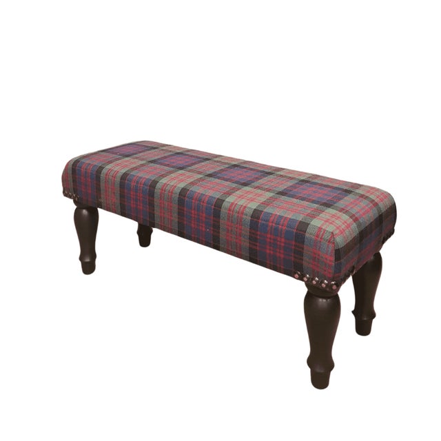 Meticulously handcrafted in the United Kingdom, this upholstered stool boasts classic studding and hand-polished solid...