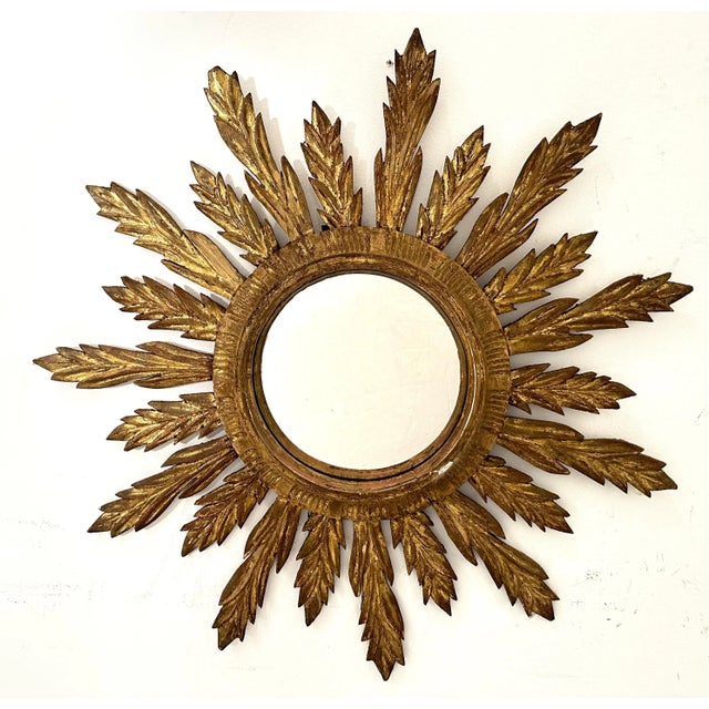 A lovely French convex gilt sunburst (or starburst) mirror with beautifully gilded wooden rays arranged around the convex...
