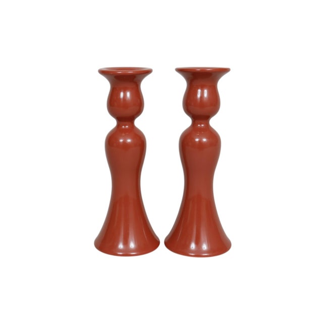 A pair of Fitz and Floyd ceramic candlestick holders in cinnabar red, made in Japan. Tulip shaped, with curvaceous...