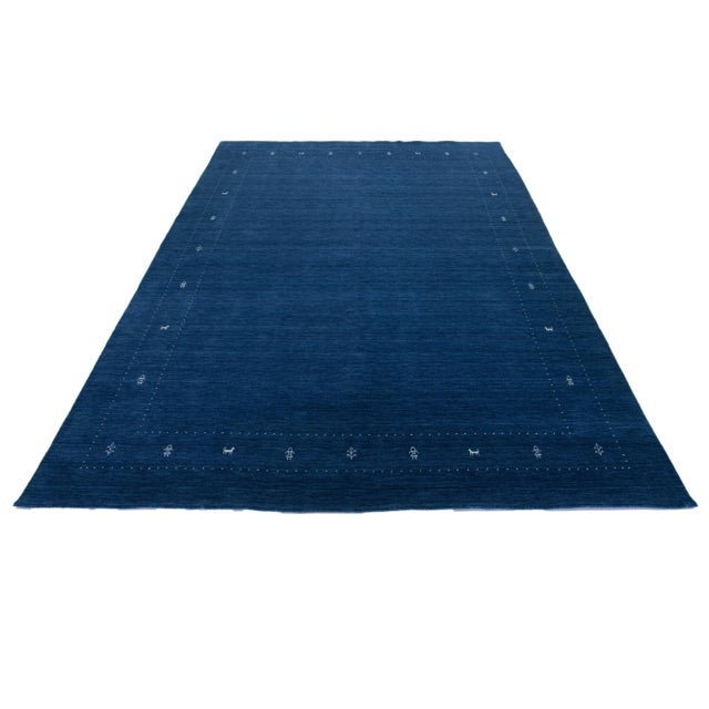 This modern Gabbeh rug is hand-loomed with a contemporary minimalist geometric pattern. The blue base is accented with...