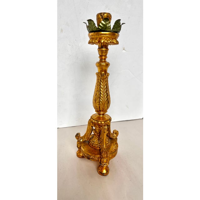 Imported from Italy. Pair of ornate gold gilded ball foot wood candle holders. Acanthus leaves adorn the stem and the...