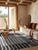 A hand-knotted wool rug, made in India and measuring 5' x 8'. Loose, abstract drawing rather than a formal repeating...