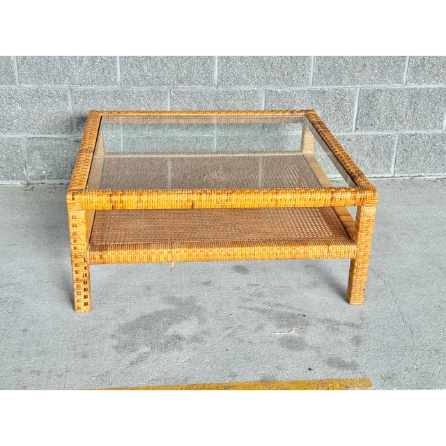 Vintage Billy Baldwin style coffee table. Woven detailing on the base with a cane shelf. Glass top. 35.5”w x 15”h. Glass...