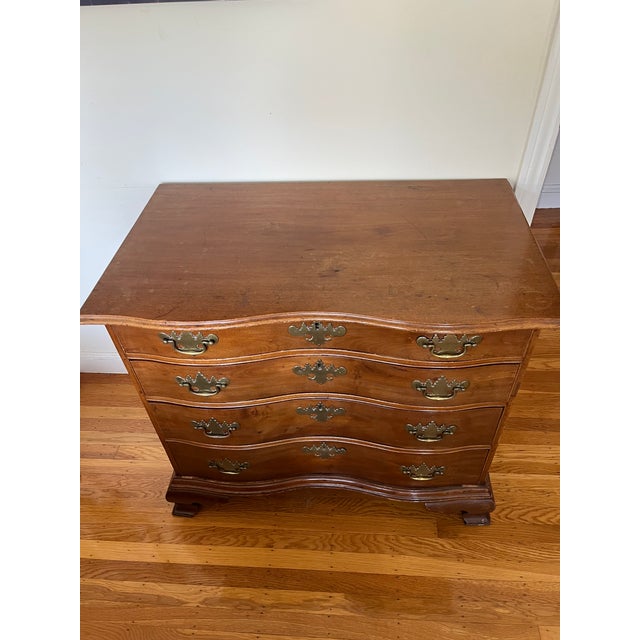There's no maker's mark, but it looks like a mahogany Chippendale dresser. It's not in awesome shape -- the top has some...