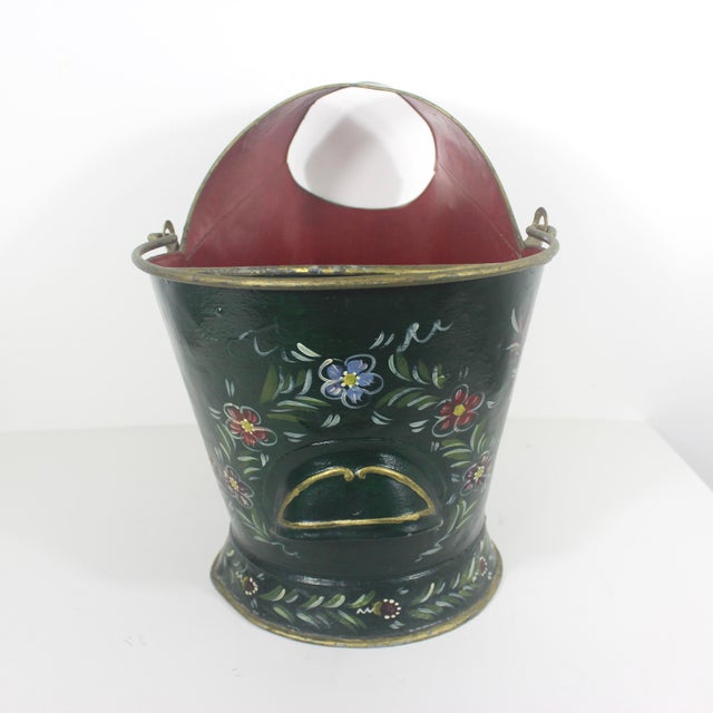 This is a large antique coal scuttle that is well worn, has dents, bumps and at some point a metal patch has been applied...